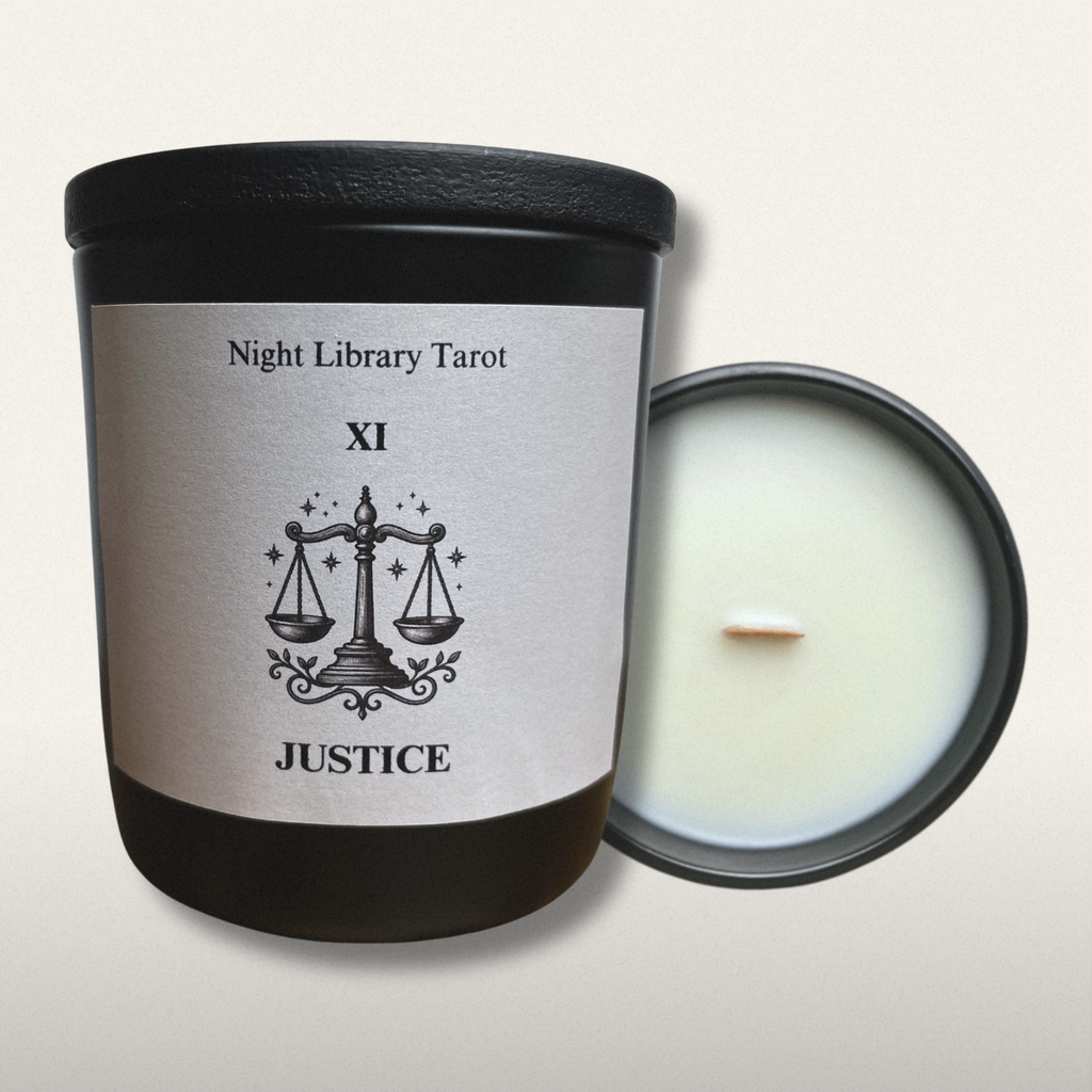 Candle with 'Night Library Tarot Justice' label on a light gray background