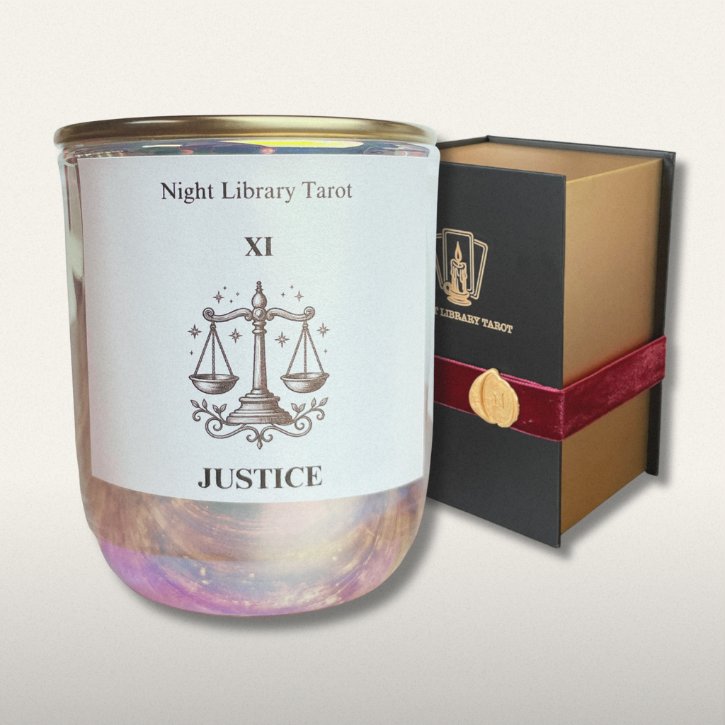 Candle with 'Justice' design and 'Night Library Tarot' packaging on a light gray background