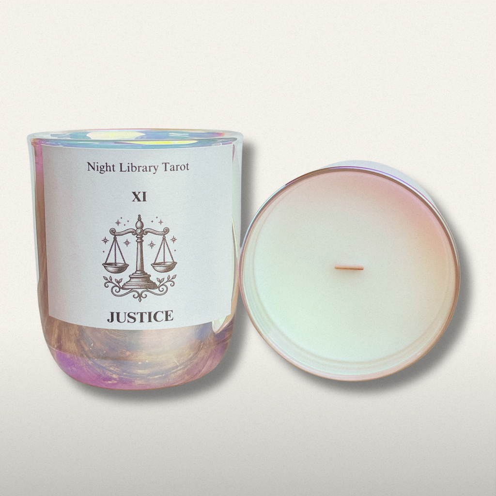 Candle in a glass jar with a label featuring 'Night Library Tarot' and 'XI Justice' on a light background.