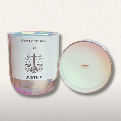 Candle in a glass jar with a label featuring 'Night Library Tarot' and 'XI Justice' on a light background.