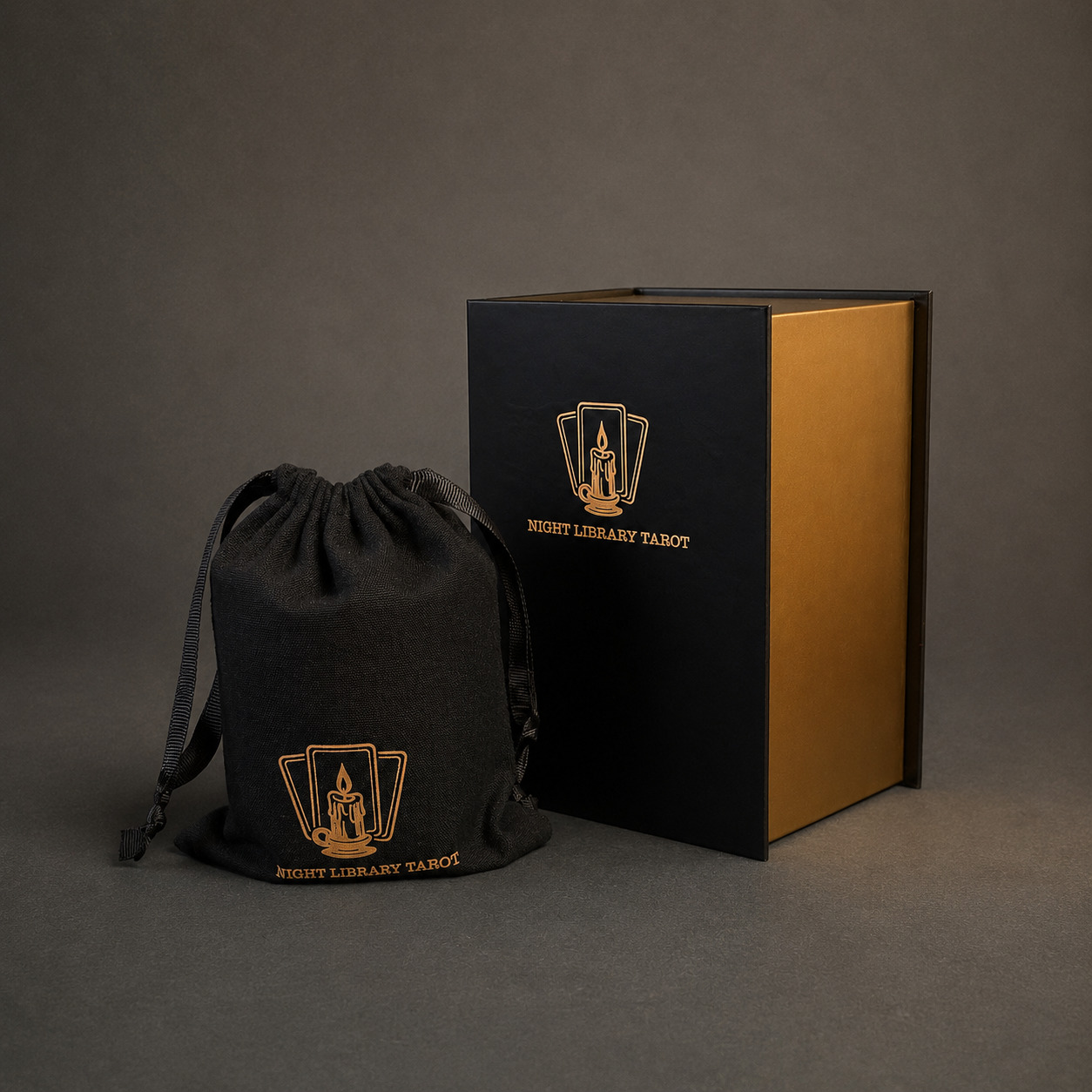 A black drawstring pouch and a black presentation box with gold foil printing for the 'Night Library Tarot' set, photographed on a dark gray studio background.