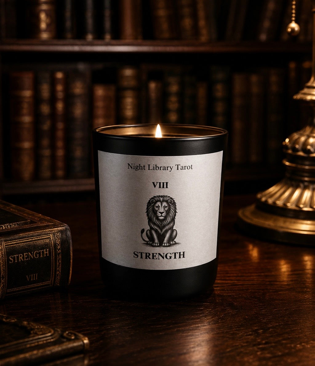 Candle with a label featuring a lion and text, set against a bookshelf background. Strength Luxury Candle Tarot Inspired 