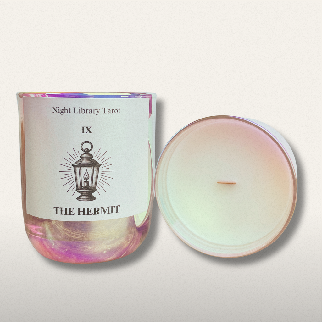 Candle with a label titled 'The Hermit' from Night Library Tarot on a light background