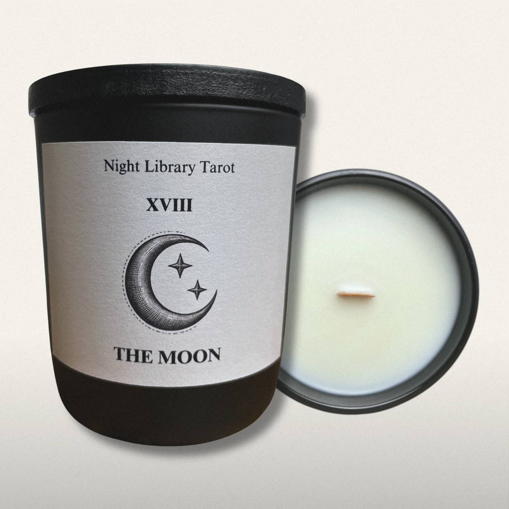 Candle with a label featuring a moon and star design, titled 'The Moon' from 'Night Library Tarot'.