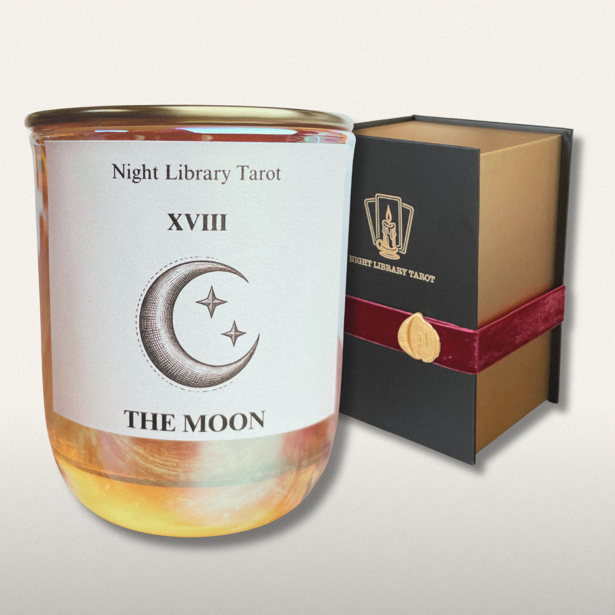 Candle labeled 'The Moon' from Night Library Tarot with packaging on a light gray background
