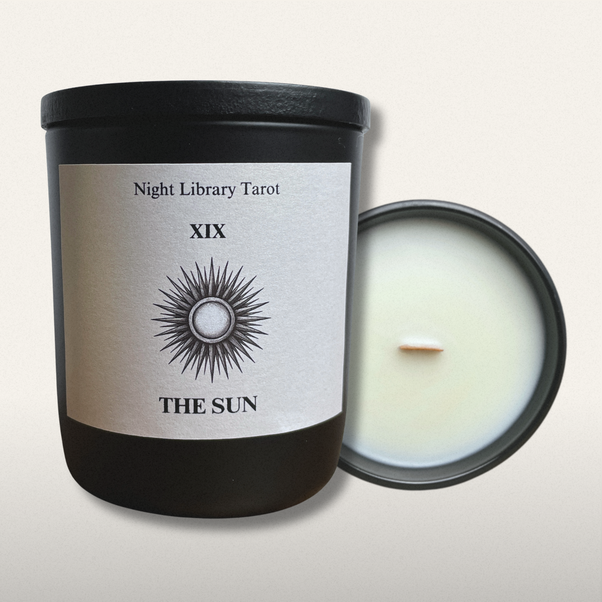 Candle with a label titled 'The Sun' from Night Library Tarot on a light gray background