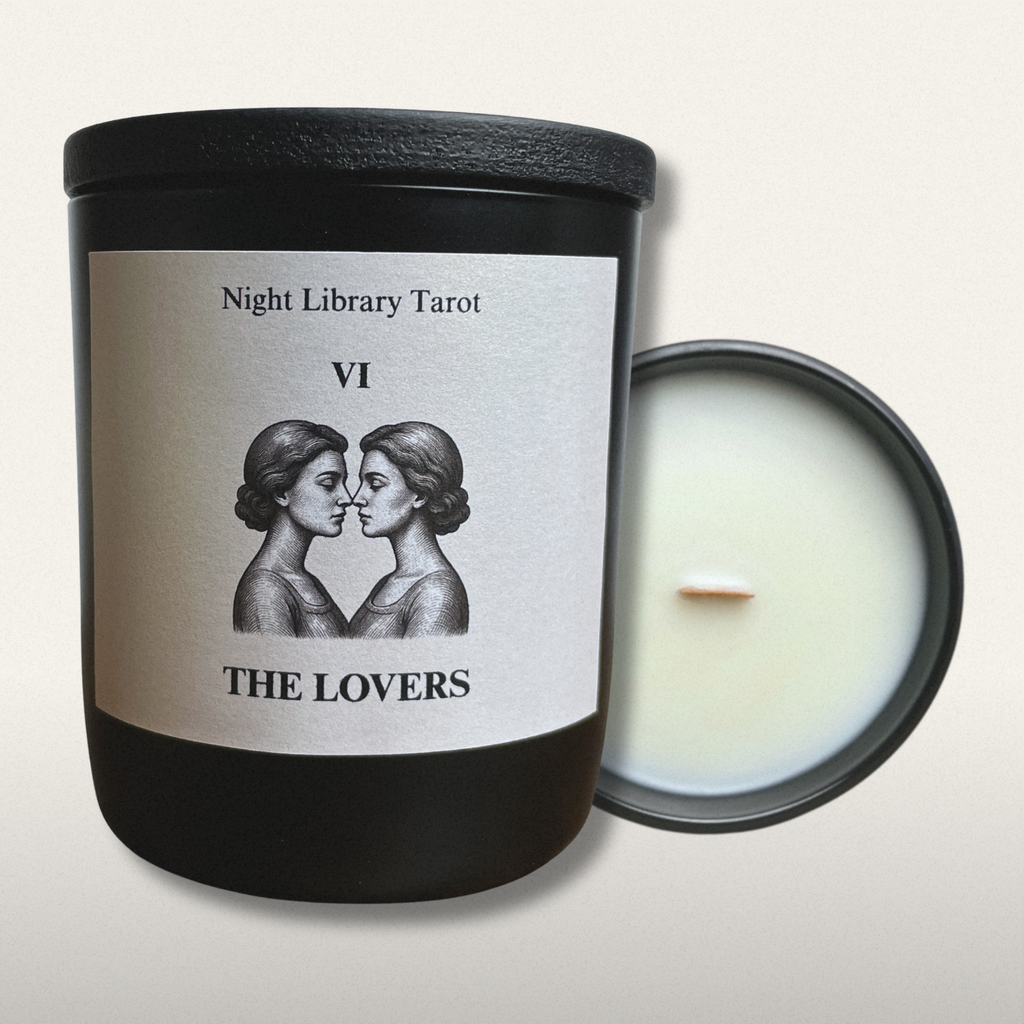 Candle with a label featuring 'The Lovers' from Night Library Tarot on a light gray background